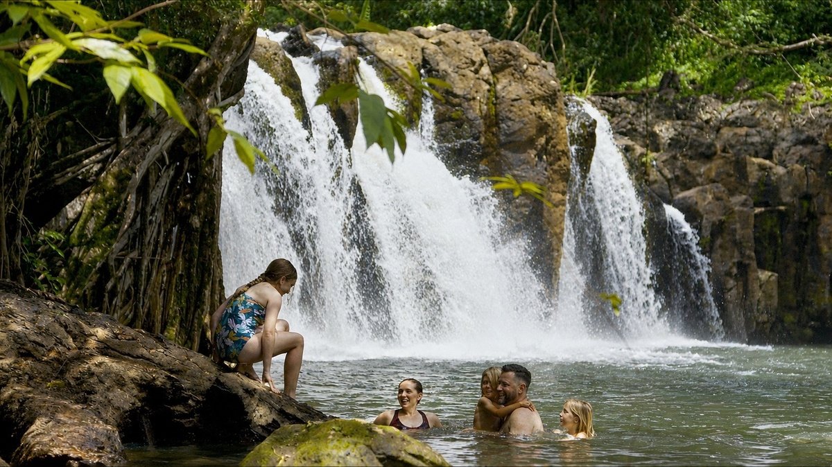 Guests enjoying the pool beside Kīpū Falls
