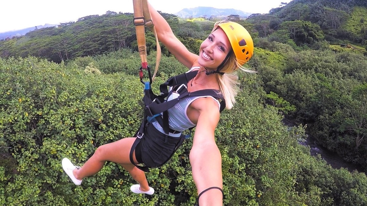 A guest ziplines above the rainforest with Kauai Backcountry Adventures