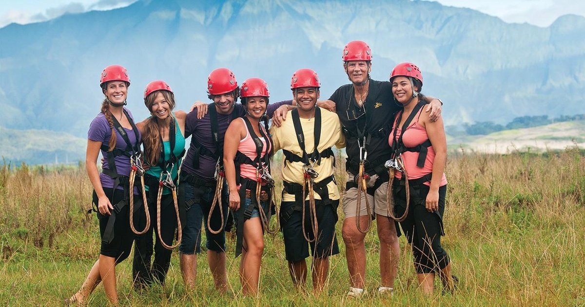 A group in zipline harnesses on the Kīpū Zipline Safari