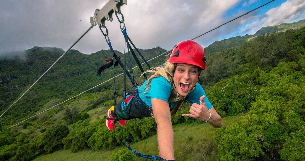 A guest flies headfirst above the green valley on the Nui zipline tour